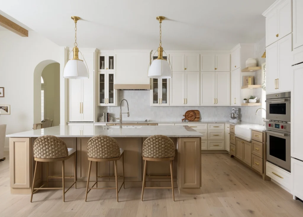 Bright Southlake kitchen with a large island, white cabinetry, and brass lighting