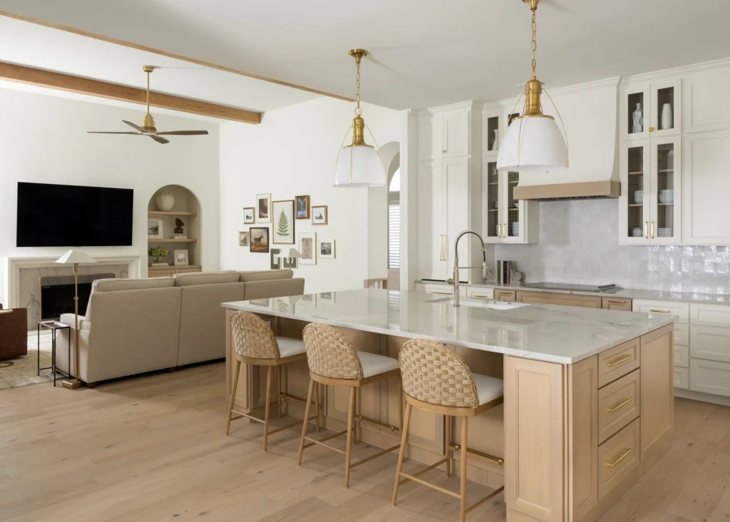 Open-concept kitchen and living room with a large island and warm neutral finishes