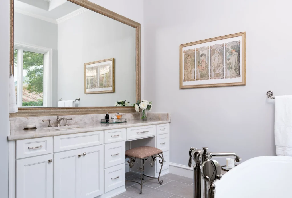 Primary bathroom with white double vanity, large mirror, and freestanding tub in Forest Glen I