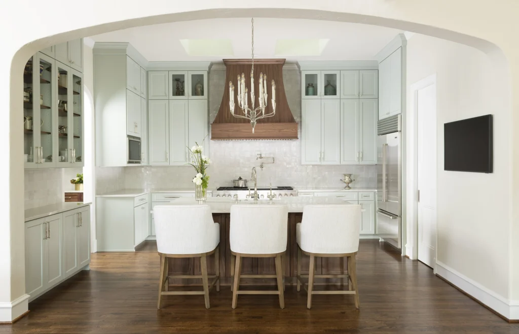 Bright white kitchen with copper range hood and island seating in the Forest Glen II remodel