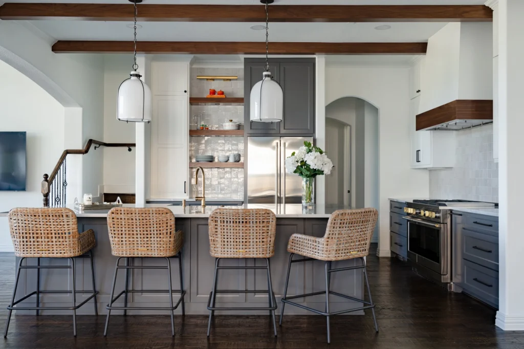White and gray kitchen with island seating and exposed wood beams in the Galloway remodel