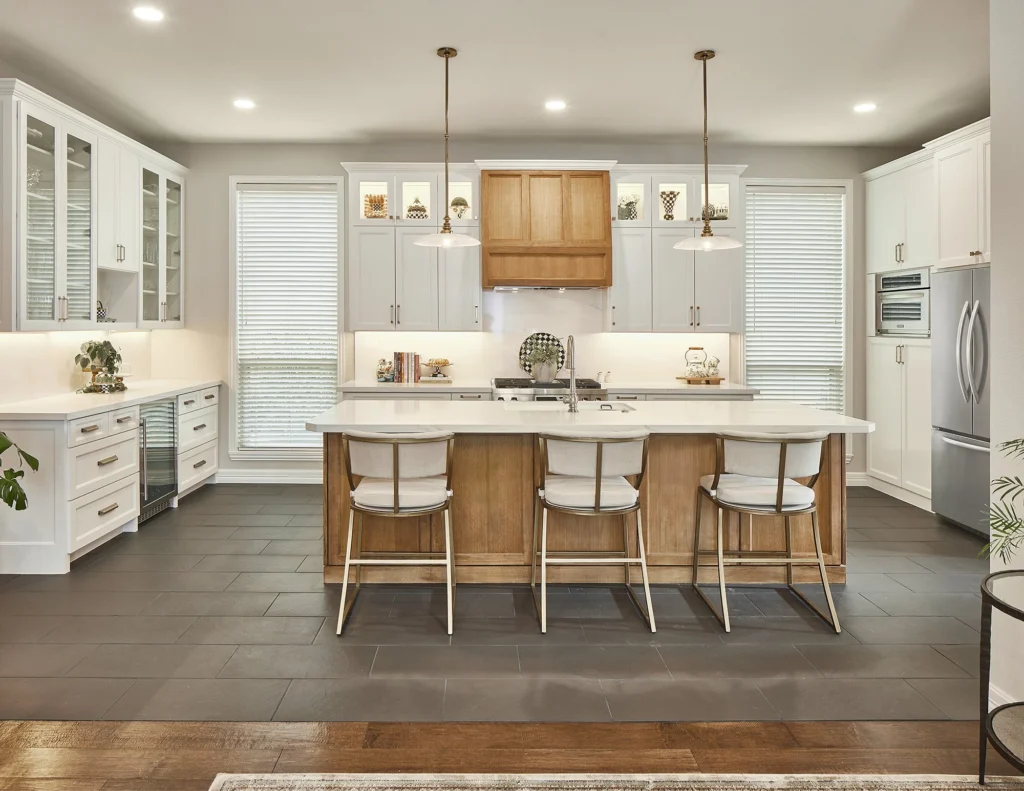 Bright white kitchen with large island, crystal chandelier, and custom cabinetry in Longfellow