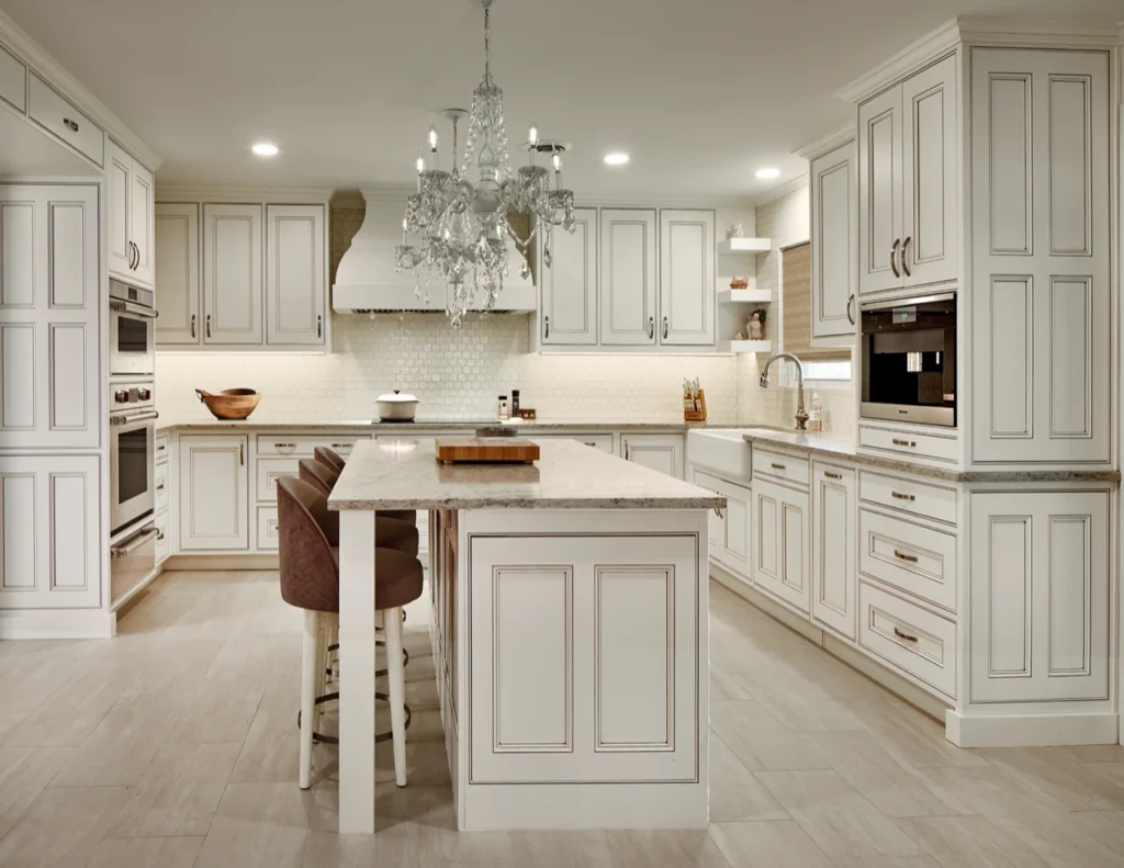Elegant white kitchen with detailed cabinetry, central island, and crystal chandelier at Sunee Ranch