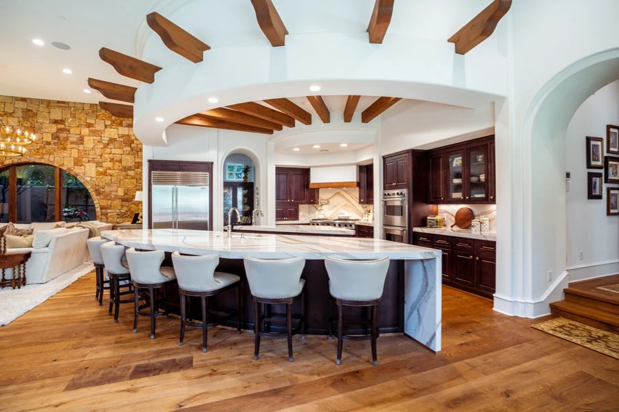 Open-concept kitchen with exposed wood beams and large island in the Westlake I remodel