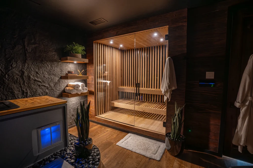 Private wellness room with wood sauna, stone wall, and ambient lighting in Westlake II
