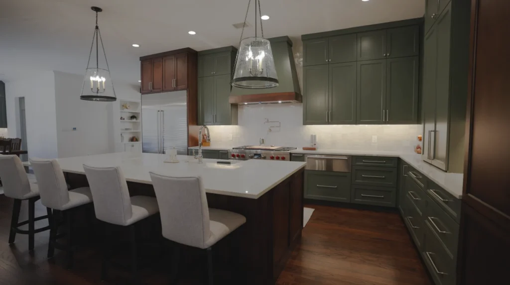 Southlake kitchen island with white countertop, upholstered seating, and green cabinetry